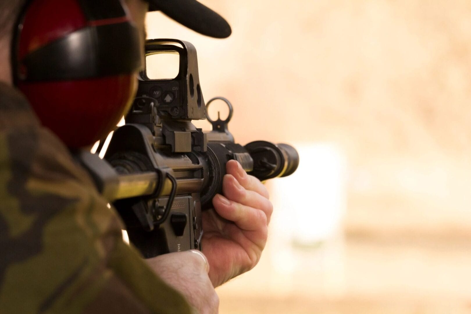 A person holding an ar-1 5 rifle with a scope.